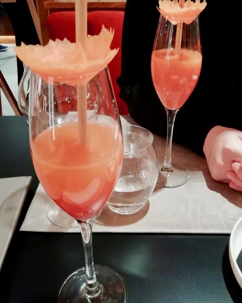 Deux cocktails gingembre, carotte hibiscus, servis dans des flûtes à champagne